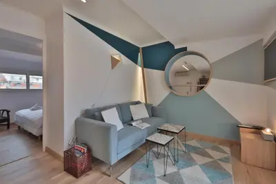 a living room with a blue couch and a mirror at Belle surprise cœur de ville, cosy avec terrasse in Cannes