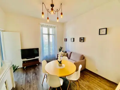 a living room with a table and a couch at Deux pièces proche Palais et plages in Cannes