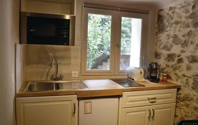 a kitchen with a sink and a microwave and a window at Studio Suquet Saint Antoine in Cannes