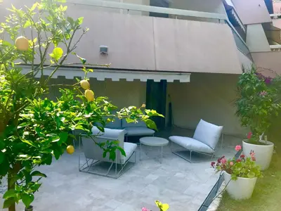a patio with a table and chairs and some plants at 19 Rue du Parc Alexandre III in Cannes