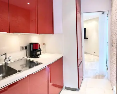 a kitchen with red cabinets and a sink at 19 Rue du Parc Alexandre III in Cannes
