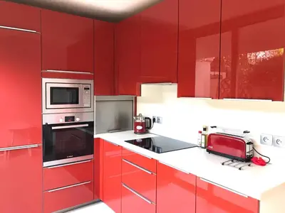 a red kitchen with white counter tops and red cabinets at 19 Rue du Parc Alexandre III in Cannes