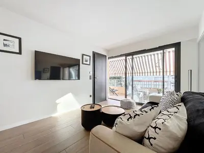 a living room with a couch and a large window at 3P BETWEEN CROISETTE BEACHES AND ANTIBES STREET in Cannes