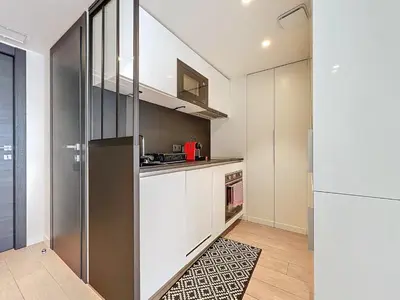 a kitchen with white cabinets and a refrigerator at 3P BETWEEN CROISETTE BEACHES AND ANTIBES STREET in Cannes