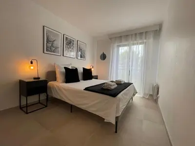 a bedroom with a bed and a window at Domaine D'Ahmosis, modern 2 bedrooms refurbished apartment, f3 moderne fraichement rénové in Le Cannet