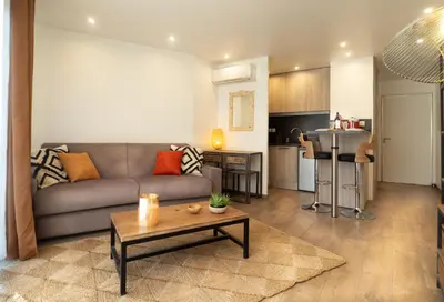 a living room with a couch and a table at Très jolie studio au pied du Suquet Cannes in Cannes