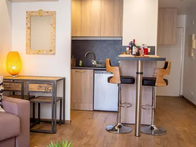 a kitchen and living room with a counter and a table at Très jolie studio au pied du Suquet Cannes in Cannes