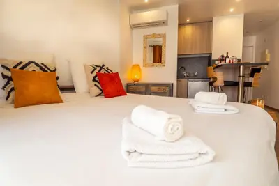 a bedroom with a large white bed with towels on it at Très jolie studio au pied du Suquet Cannes in Cannes