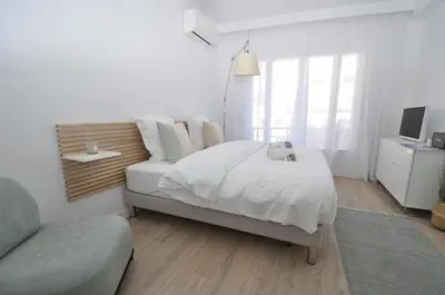 a white bedroom with a bed and a couch at 9 Rue Buttura in Cannes