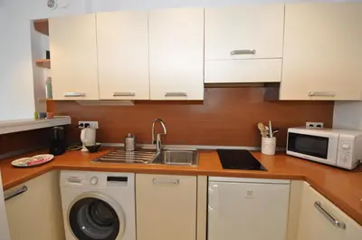 a kitchen with white cabinets and a sink and a microwave at 9 Rue Buttura in Cannes
