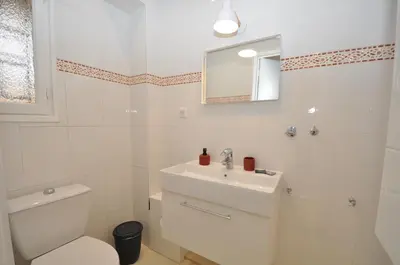 a white bathroom with a toilet and a sink at 9 Rue Buttura in Cannes