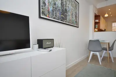 a living room with a tv on a white wall at 9 Rue Buttura in Cannes