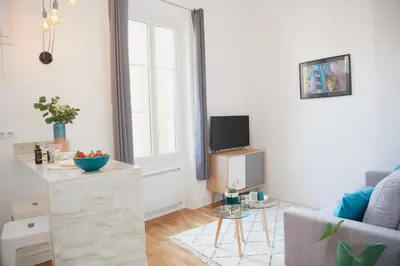 a living room with a couch and a tv at 6 Rue Coste Corail in Cannes