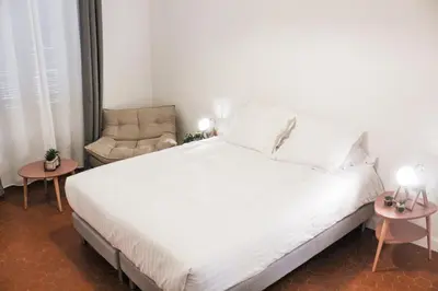 a bedroom with a white bed and a chair at Best quality price ! - Central - 350m Palais and Croisette in Cannes