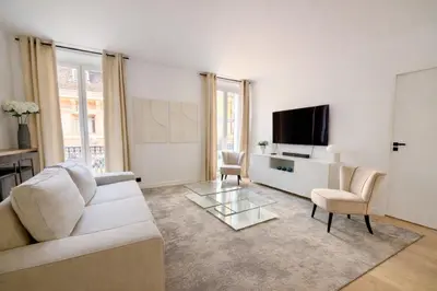 a living room with a white couch and a flat screen tv at Luxueux 3 pièces de 80m2 -2 chambres, 2 salles de bain- A 1mn de la Croisette et des plages in Cannes