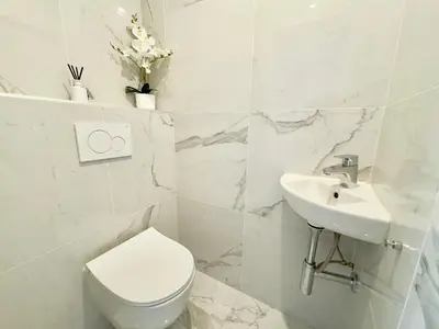 a bathroom sink with a vase of flowers on it at Luxueux 3 pièces de 80m2 -2 chambres, 2 salles de bain- A 1mn de la Croisette et des plages in Cannes