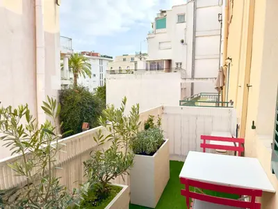 a table and chairs on the balcony of a house at Luxueux 3 pièces de 80m2 -2 chambres, 2 salles de bain- A 1mn de la Croisette et des plages in Cannes