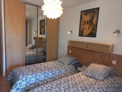 a hotel room with two beds and a mirror at Cannes Vacances chez Steph in Cannes