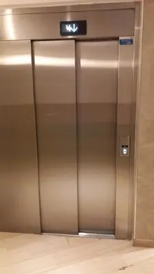 an elevator door in a building with a sign on it at Calm Flat in Cannes