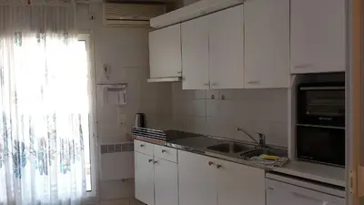 a kitchen with white cabinets and a sink and a window at Calm Flat in Cannes