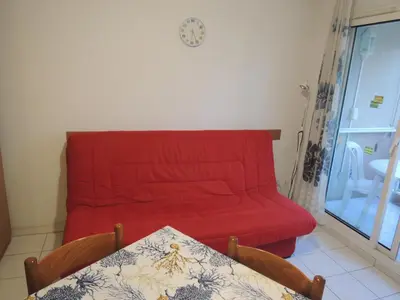 a living room with a red couch and a table at Calm Flat in Cannes