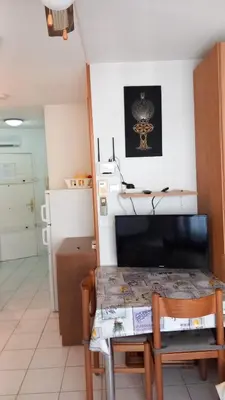 a kitchen with a table and a small kitchen with a refrigerator at Calm Flat in Cannes