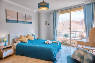 a bedroom with a blue bed with a stuffed animal on it at Grand Studio Cannes Centre in Cannes