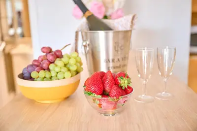 a table with a bowl of fruit and wine glasses at Grand Studio Cannes Centre in Cannes