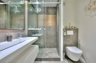 a bathroom with two sinks a toilet and a shower at REF 1147 - Cannes Center - Apartment for rent in Cannes