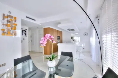 a dining room with a glass table and a kitchen at REF 1147 - Cannes Center - Apartment for rent in Cannes