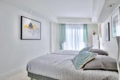 a white bedroom with a bed and a window at REF 1147 - Cannes Center - Apartment for rent in Cannes