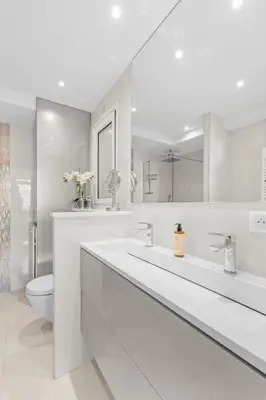 a white bathroom with two sinks and a toilet at REF 1181 - Cannes Croisette - Sea view apartment for rent in Cannes