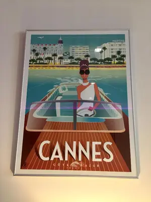a poster of a woman sitting on a surfboard at Hotel Cannes Croisette in Cannes