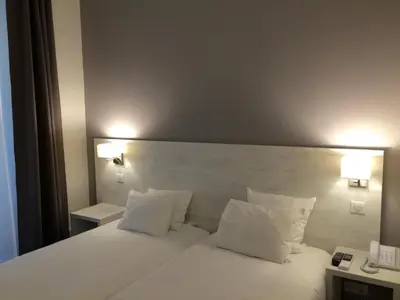 a hotel room with a white bed with two pillows at Hotel Cannes Croisette in Cannes