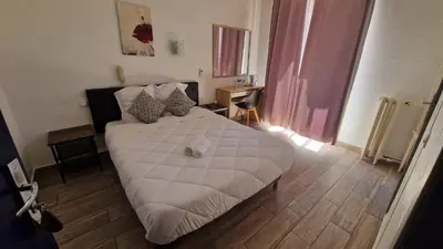 a bedroom with a white bed in a room at Hôtel du Nord in Cannes