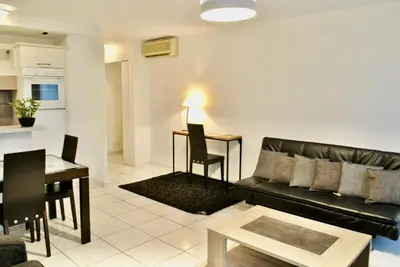 a living room with a black couch and a table at Centre Riviera 2P LHO5516 in Cannes