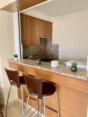 a kitchen with a counter with three bar stools at Gray d'Albion POL519 studio in Cannes