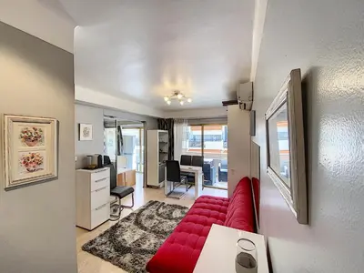 a living room with a red couch and a desk at Imperial Croisette FER3417 studio in Cannes