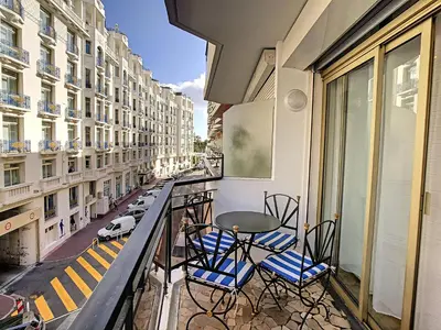 a balcony with chairs and a table and a street at Grand studio cabine à côté des plages NER634 in Cannes
