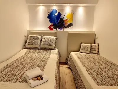 two beds in a room with a painting on the wall at Grand studio cabine à côté des plages NER634 in Cannes