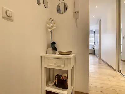 a hallway with a white table with a bowl on it at Grand studio cabine à côté des plages NER634 in Cannes