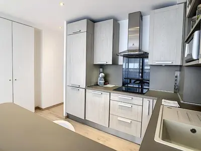 a kitchen with white cabinets and a sink at Grand studio cabine à côté des plages NER634 in Cannes
