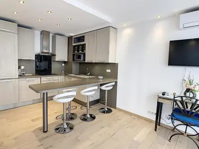 a kitchen with a table and stools in it at Grand studio cabine à côté des plages NER634 in Cannes
