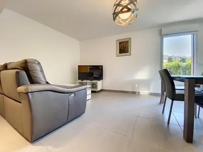 a living room with a couch and a table and a television at Montfleurie TEI142 3P in Cannes