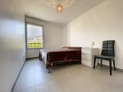 a bedroom with a bed and a chair and a window at Montfleurie TEI142 3P in Cannes