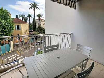 a table and chairs on a balcony with a view of a street at Le Windsor 2P DET2002 in Cannes