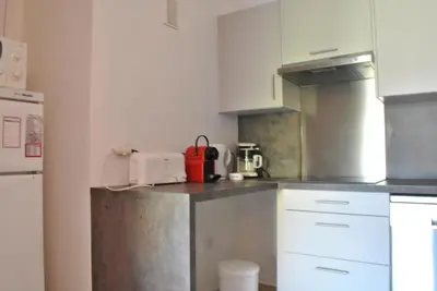 a kitchen with white cabinets and a red appliance at Le Windsor 2P DET2002 in Cannes