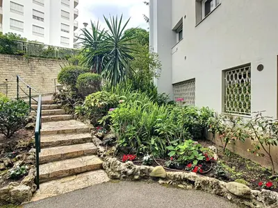 a garden with stairs and flowers in front of a building at Le Windsor 2P DET2002 in Cannes