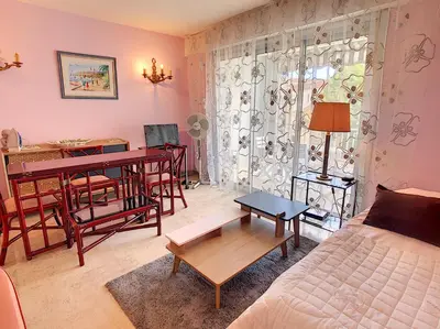 a living room with a bed and a table and a desk at Le Windsor 2P DET2002 in Cannes