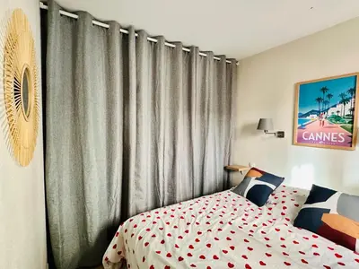 a bedroom with a bed in front of curtains at T2 superbe vue mer Cannes in Cannes